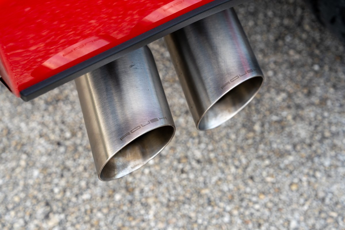 Red Ford F-150 Roush with dual exhaust tips showing the Roush logo.