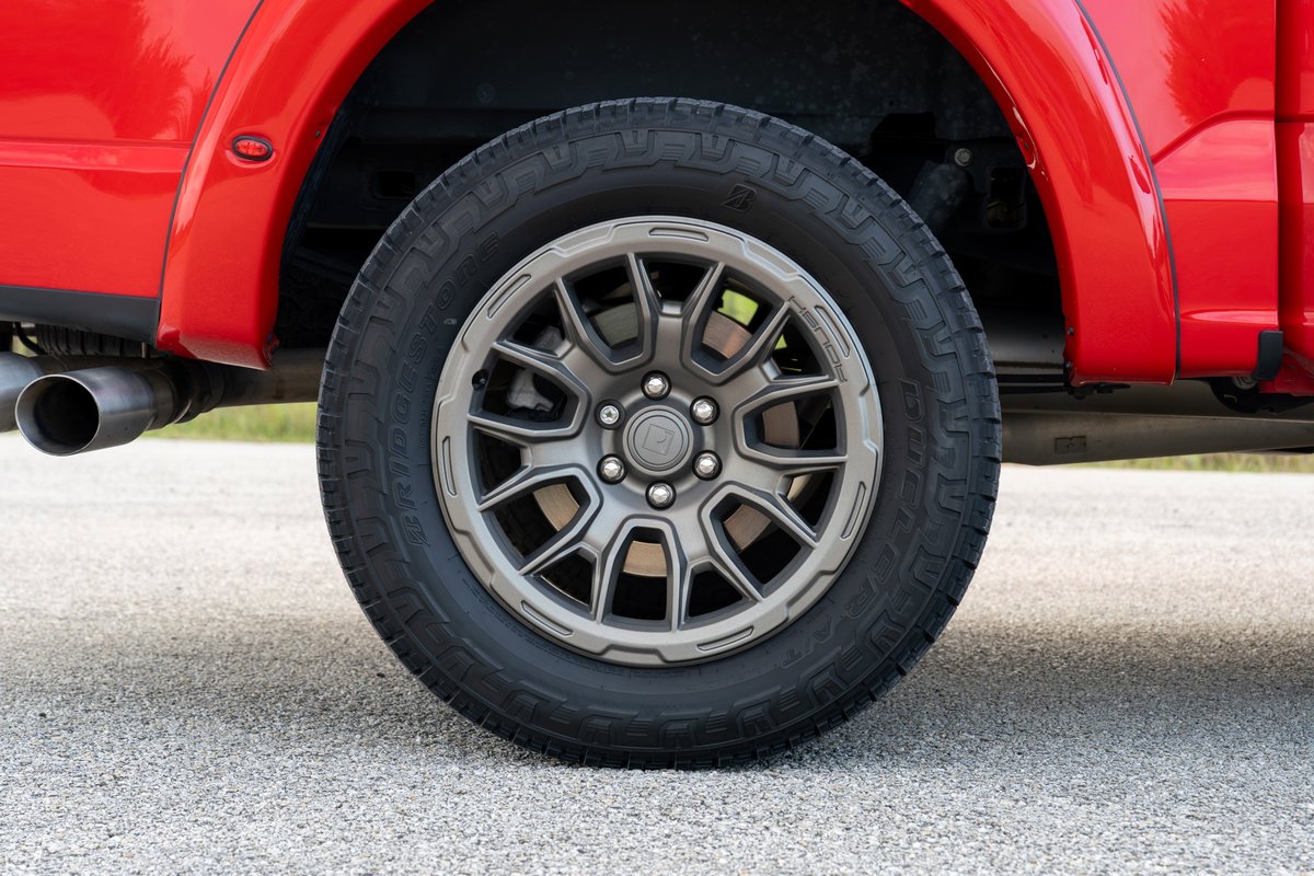 Red 2022 Ford F-150 Roush with gray multi-spoke rims and all-terrain tires.