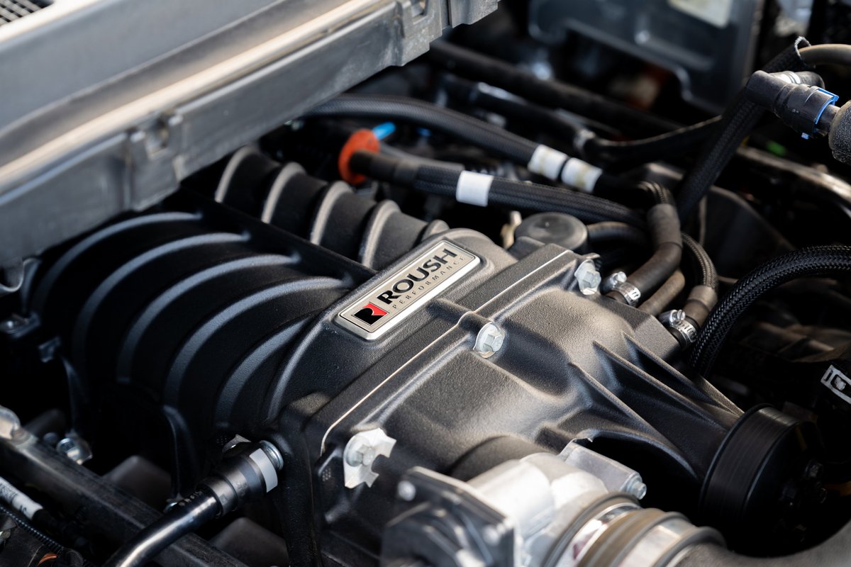 2022 red Ford F-150 Roush supercharger system with black intake manifold.