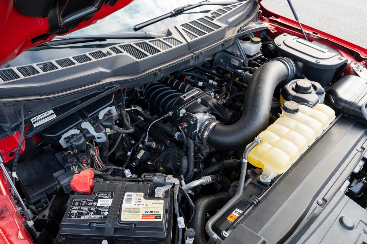 Engine bay of a red 2022 Ford F-150 Roush, featuring a supercharged V8 engine.