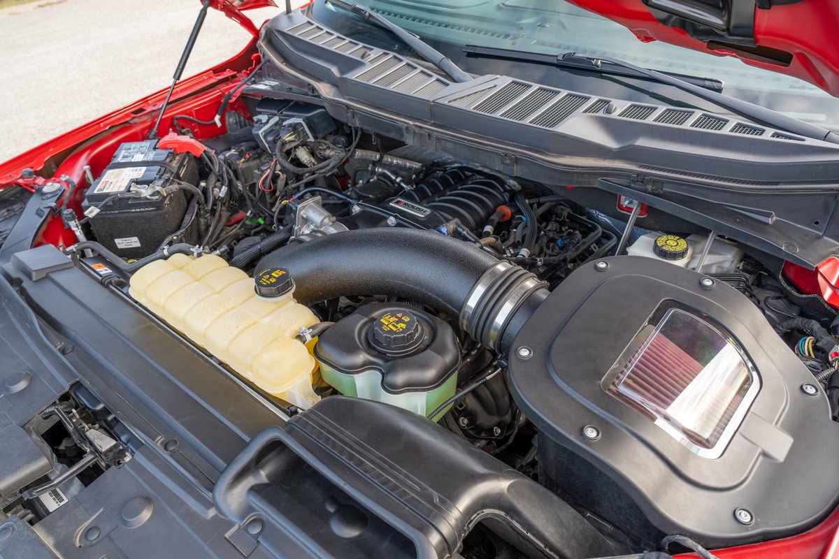 Red 2022 Ford F-150 Roush engine bay with custom cold air intake and chrome trim.
