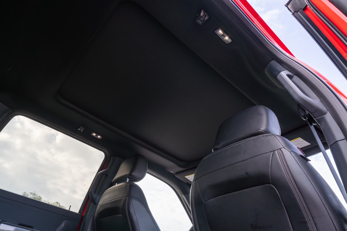 Interior view of a red 2022 Ford F-150 Roush with a panoramic sunroof.