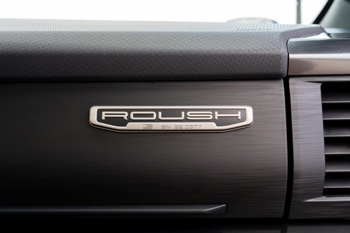 Close-up of the Roush badge on the dashboard of a 2022 red Ford F-150.