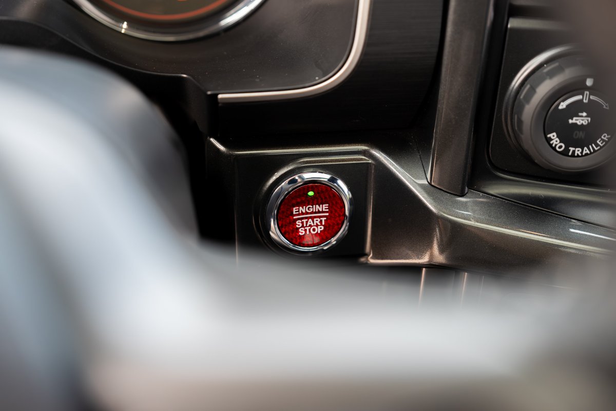 Close-up of the red 2022 Ford F-150 Roush start/stop button and Pro Trailer knob.