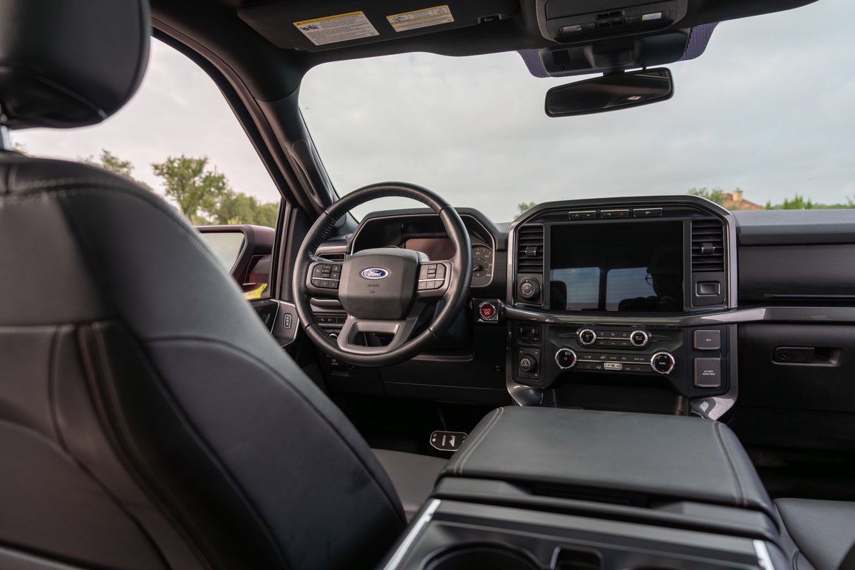 2022 Red Ford F-150 Roush interior with black leather seats and large touchscreen.