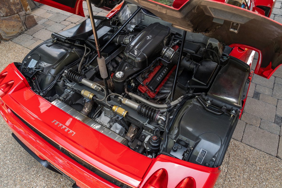 Rosso Corsa 2003 Ferrari Enzo engine bay with V12 exposed and Ferrari script.