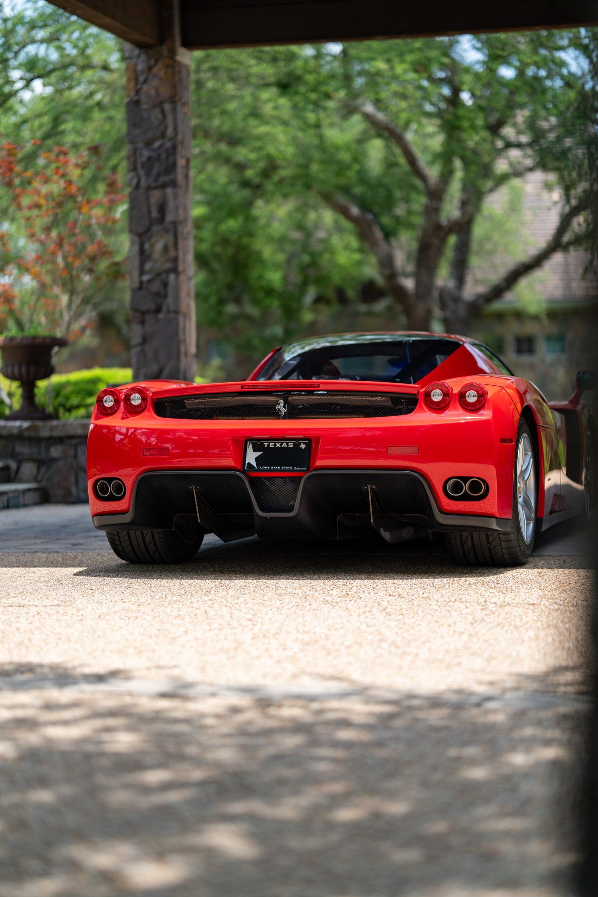 Red 2003 Ferrari Enzo rear view, showing quad exhaust and black trim.