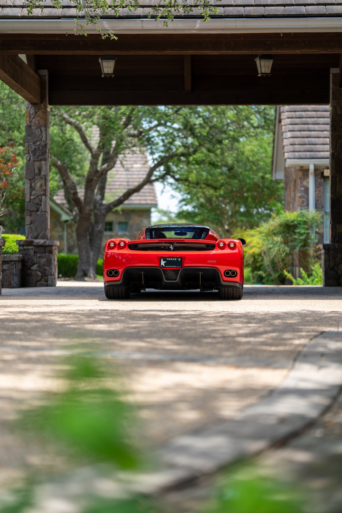 Rear view of a red 2003 Ferrari Enzo showing exhaust pipes and diffuser trim.