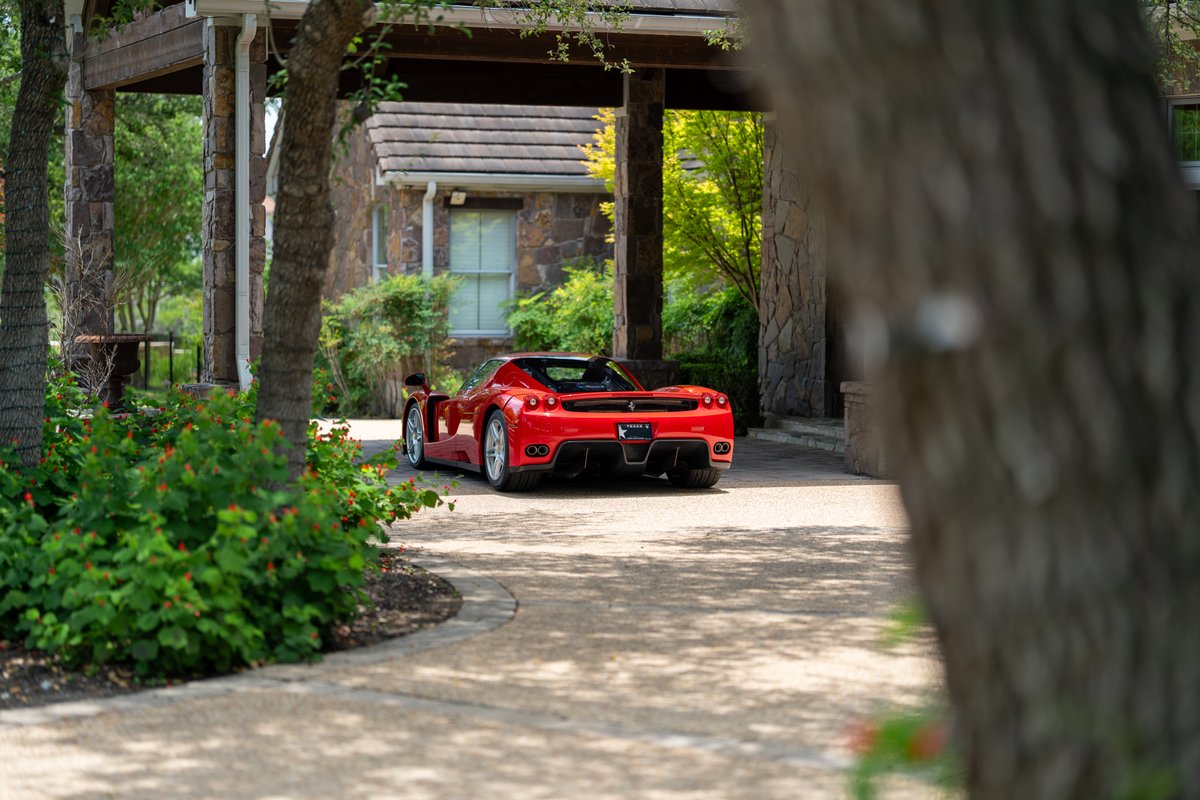 Rosso Corsa 2003 Ferrari Enzo, rear view, showing distinctive tail lights and silver rims.