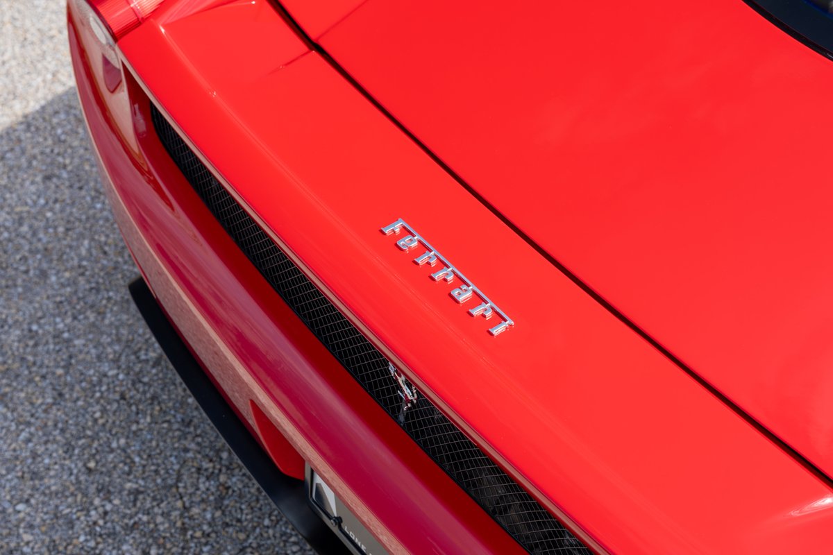 Close up of the rear of a red 2003 Ferrari Enzo, showing the Ferrari script badge.