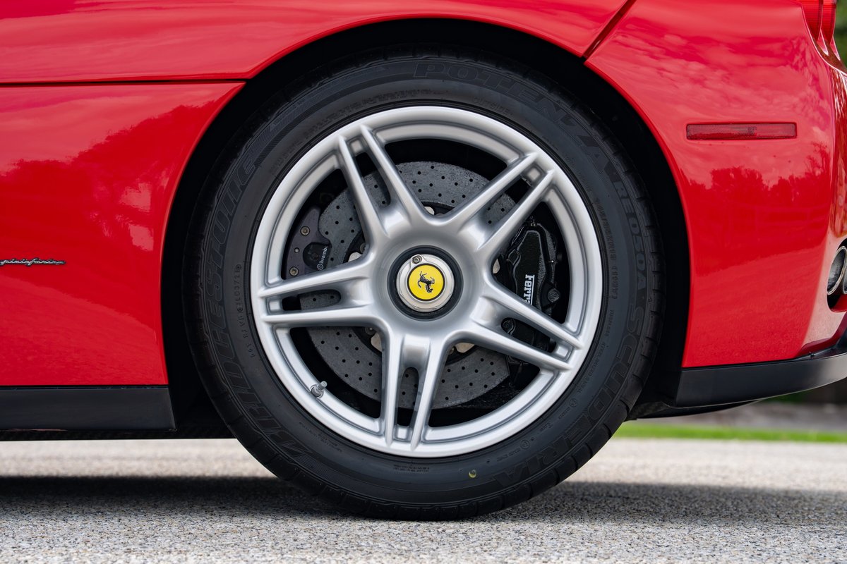 Rosso Corsa Ferrari Enzo with silver 5-spoke rims and carbon ceramic brakes.