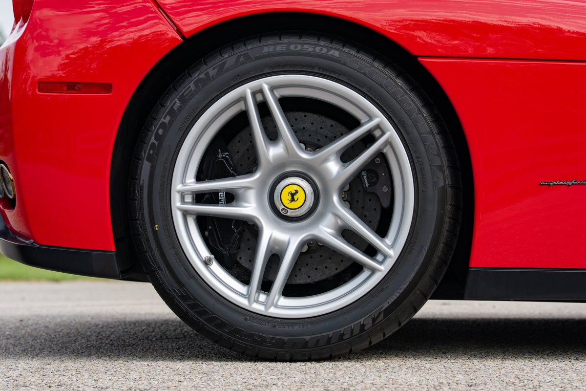 Red Ferrari Enzo rear wheel with 5-spoke alloy rims and yellow brake calipers.