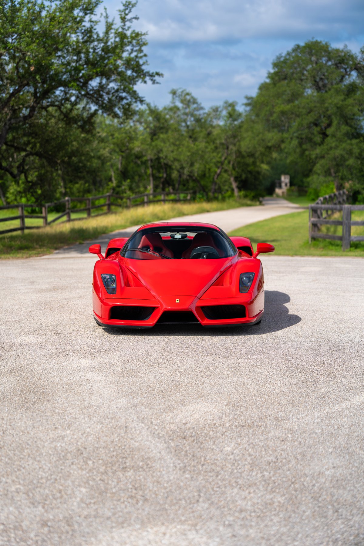 Front view of a red 2003 Ferrari Enzo with black trim and tinted headlights.