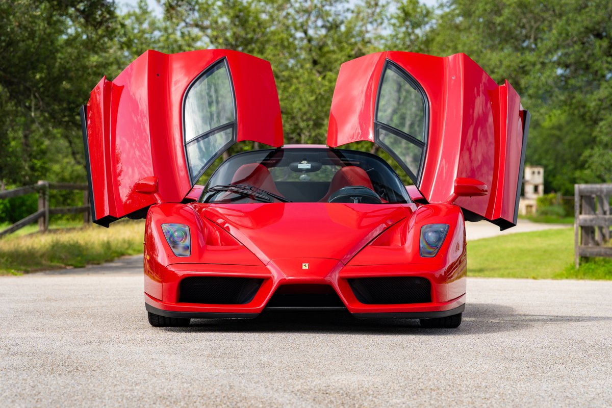 Front view of a red 2003 Ferrari Enzo with dihedral doors open.