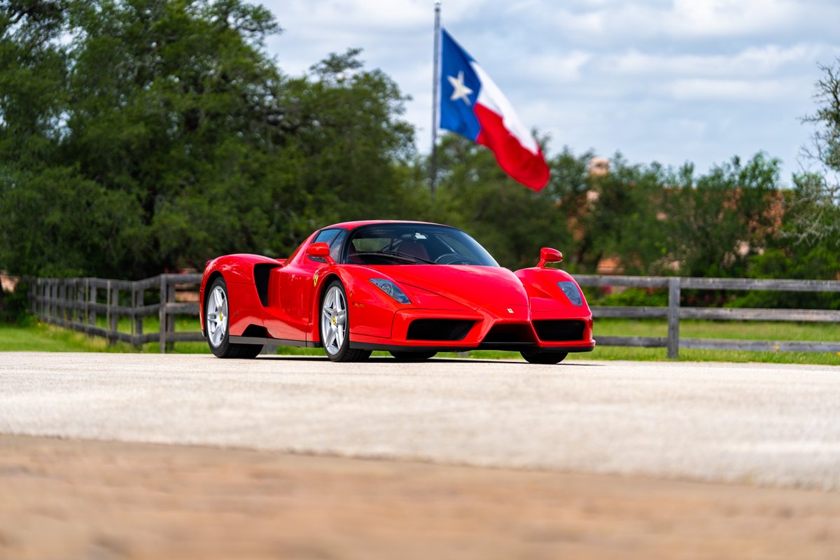 Rosso Corsa 2003 Ferrari Enzo with silver rims and Texas flag in background.