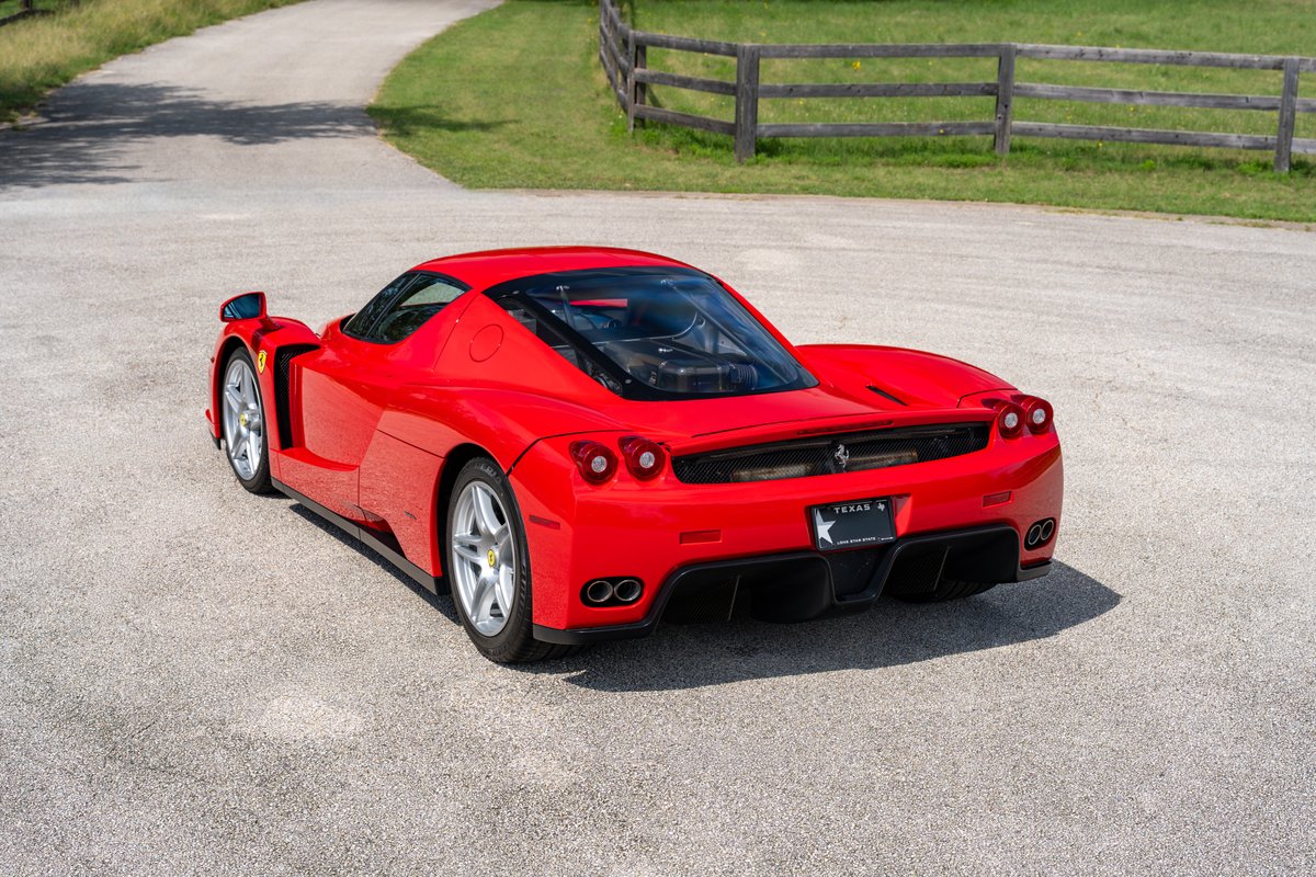 Rear 3/4 view of a Rosso Corsa 2003 Ferrari Enzo with silver rims.