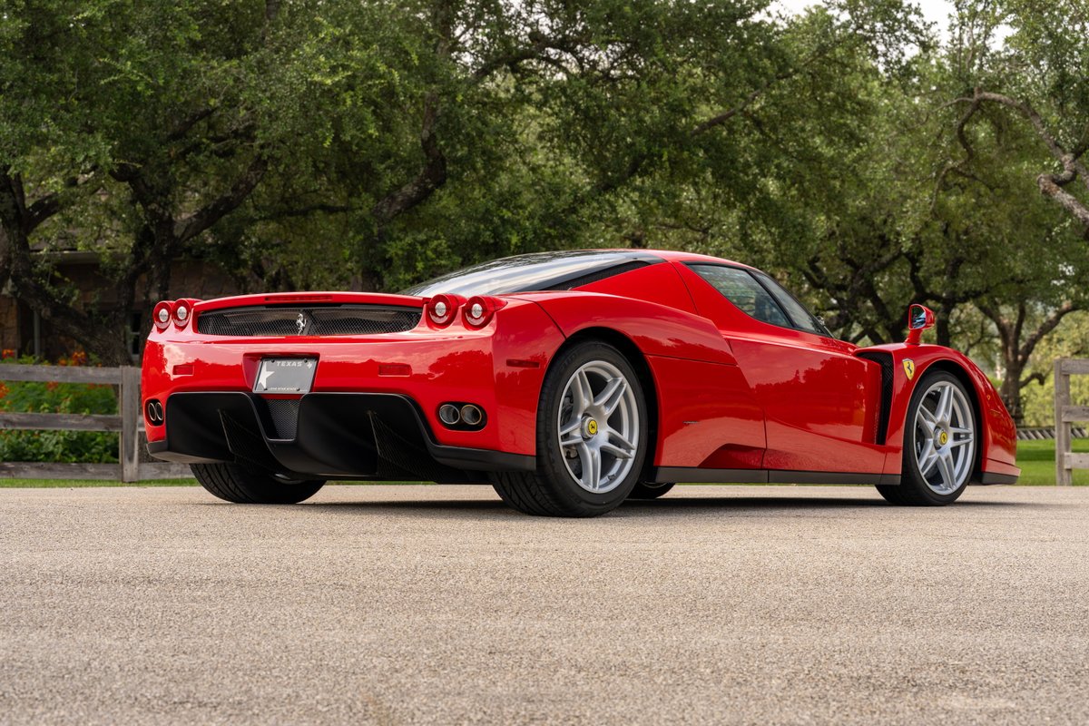Red 2003 Ferrari Enzo with silver five-spoke rims and black aero trim.