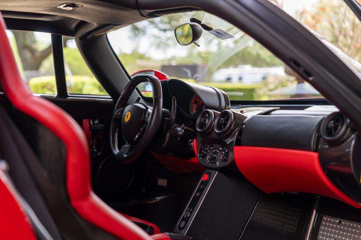 Red Ferrari Enzo interior with carbon fiber trim and racing seats.