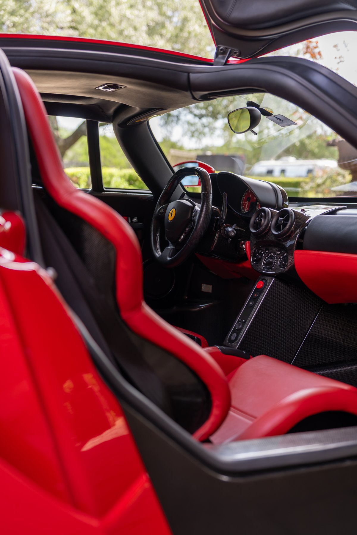 Rosso Corsa 2003 Ferrari Enzo interior, with red leather racing seats and carbon fiber trim.
