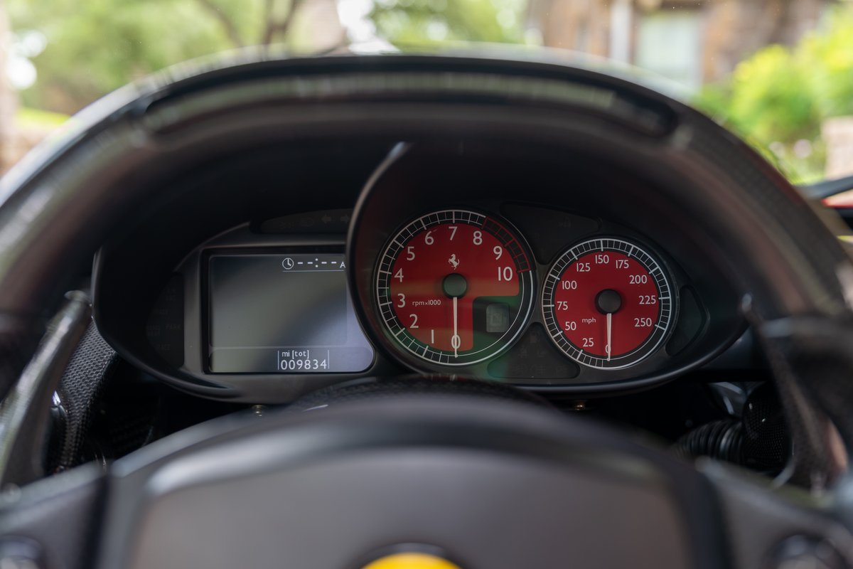 Ferrari Enzo's red tachometer and digital display dashboard.