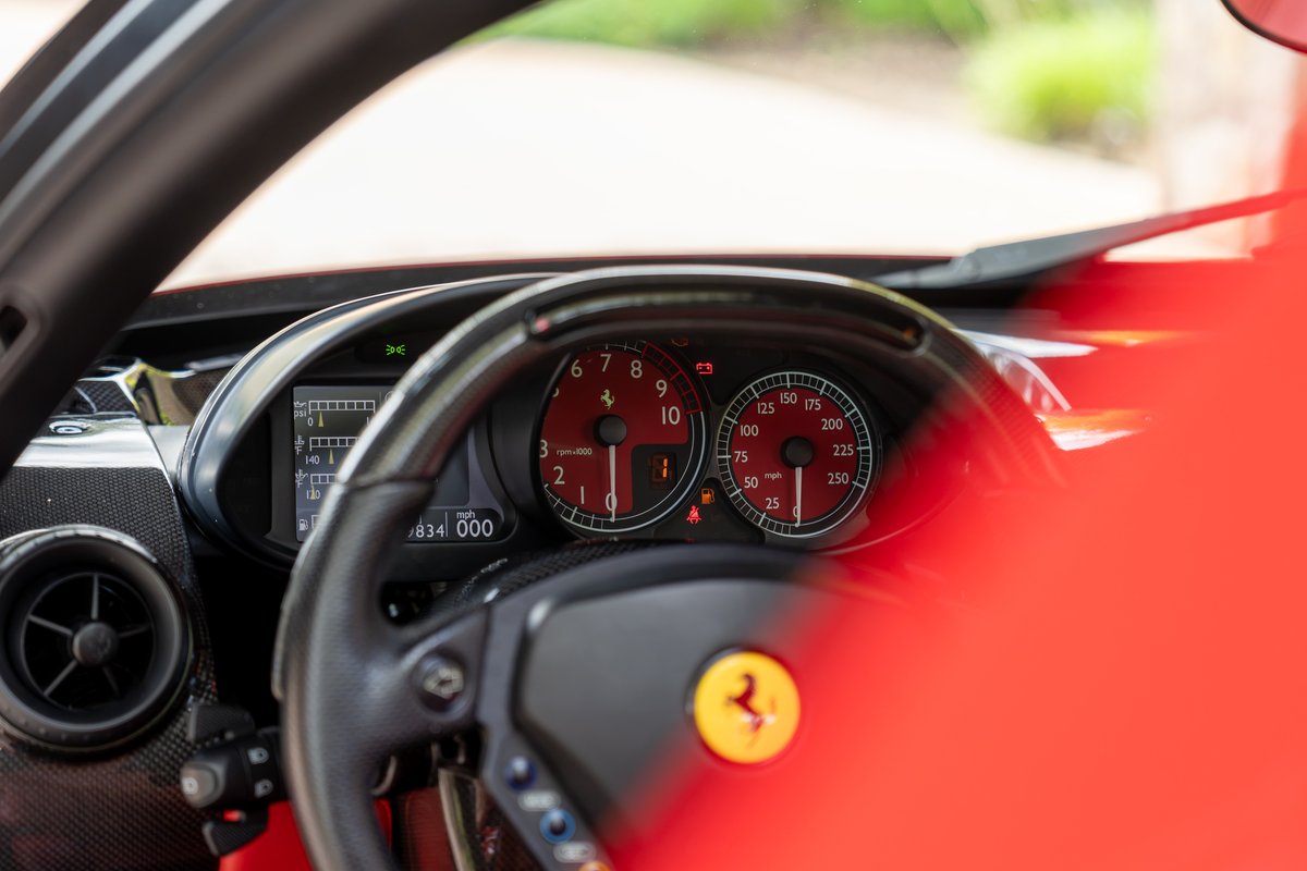 Ferrari Enzo dashboard with red gauge faces and digital display.