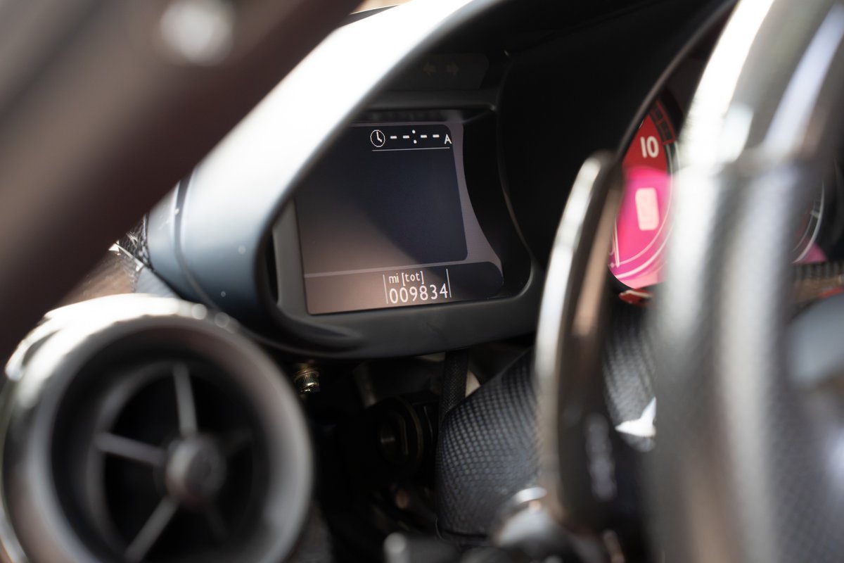 Ferrari Enzo dashboard shows digital display with 98,834 miles. Red tachometer visible.