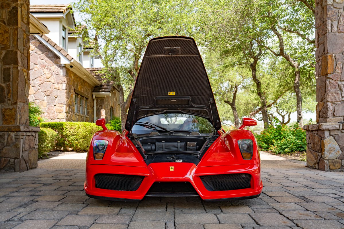 Front view of a red 2003 Ferrari Enzo with its hood open.