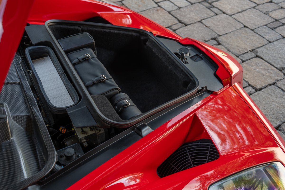 Red Ferrari Enzo's front trunk with leather luggage.