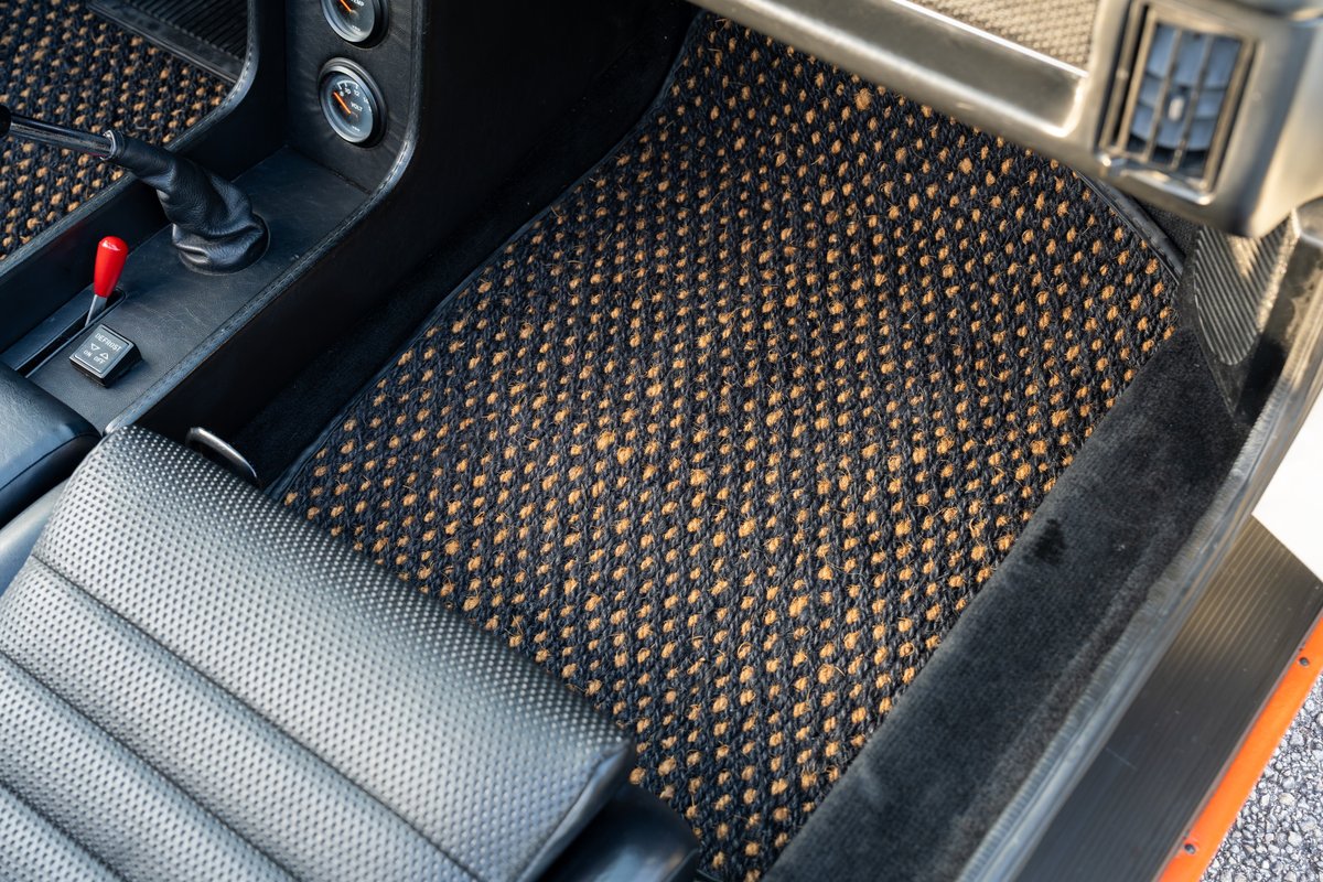 Black and tan patterned floor mats in a 1974 Porsche 914 interior with leather seats.