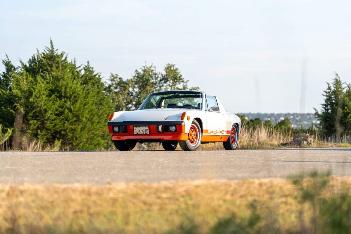 White 1974 Porsche 914 Can-Am with orange trim, livery, and rims.