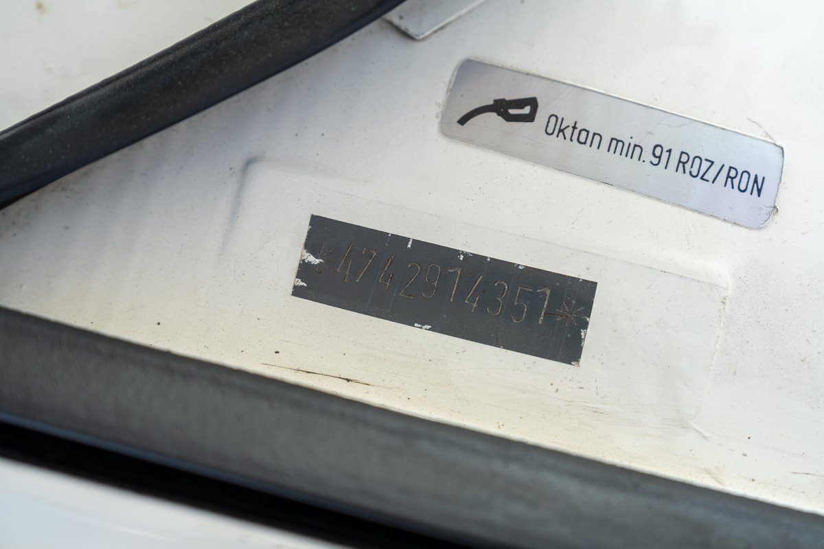 Close-up of a 1974 Porsche 914 VIN plate and fuel requirement sticker.