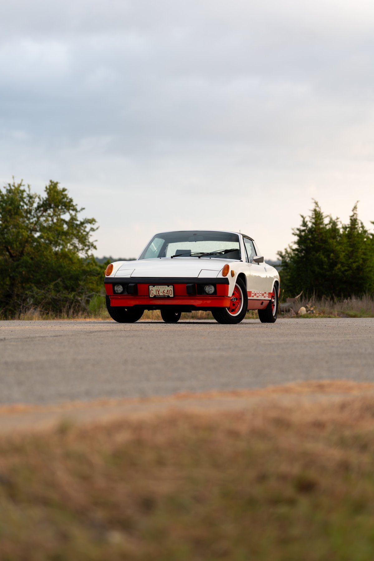 White 1974 Porsche 914 Can-Am with orange trim and rally livery.