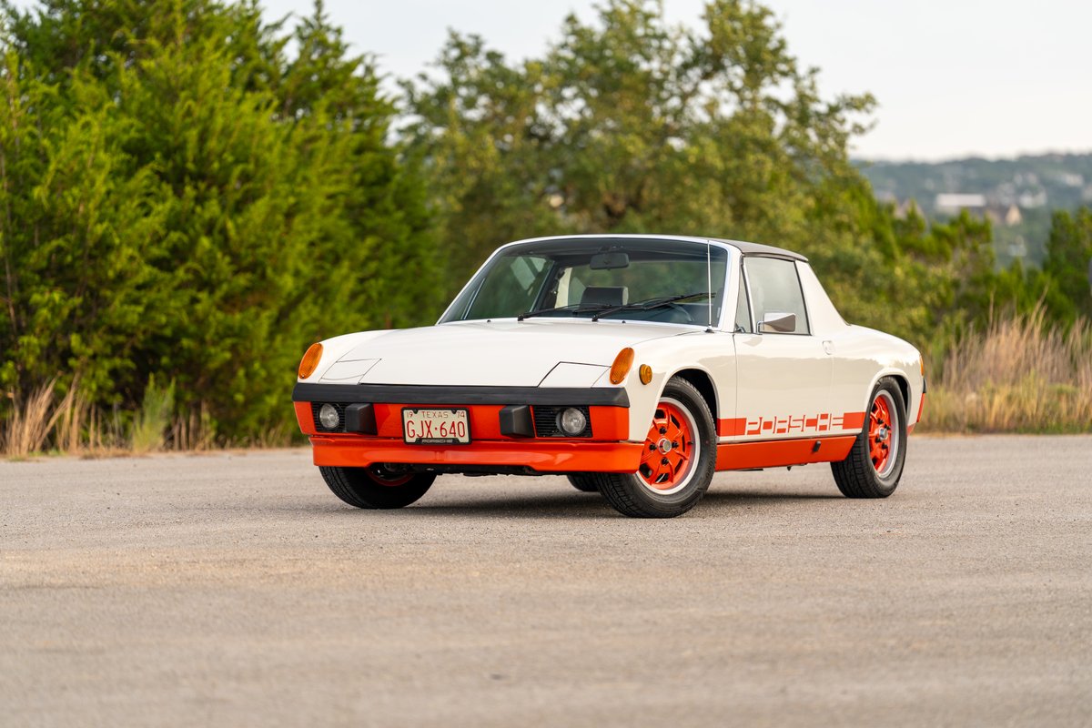 White 1974 Porsche 914 Can-Am with orange trim and wheels, and Porsche livery.