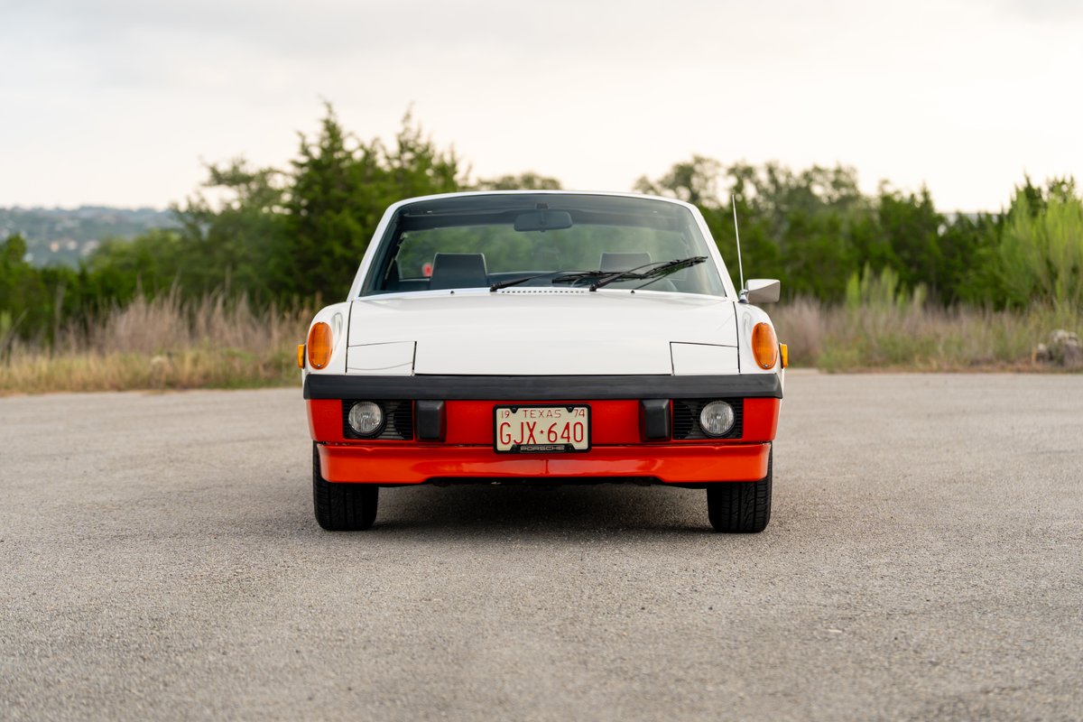 Front view of a white and orange 1974 Porsche 914 Can-Am LE with black trim.