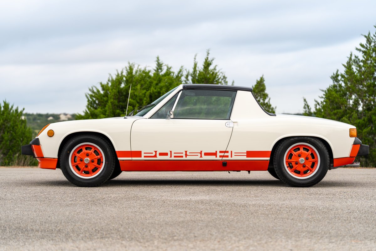 1974 Porsche 914 Can-Am in white with orange trim and wheels, side view.
