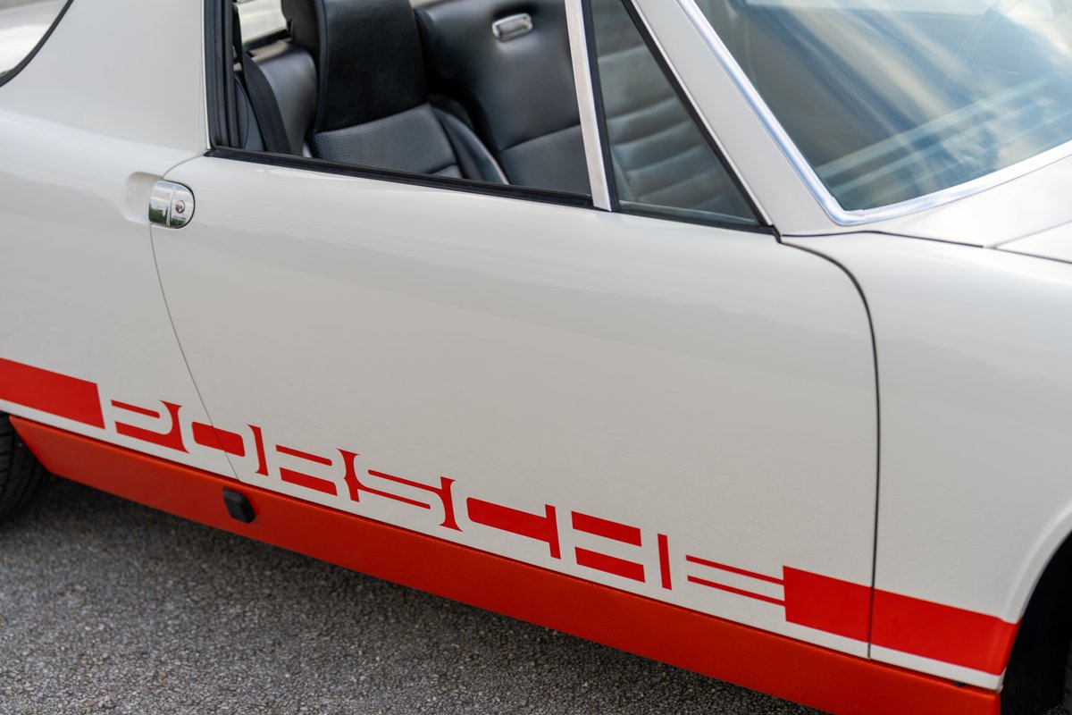 1974 Porsche 914 Can-Am has white exterior with red "Porsche" livery and racing stripe.