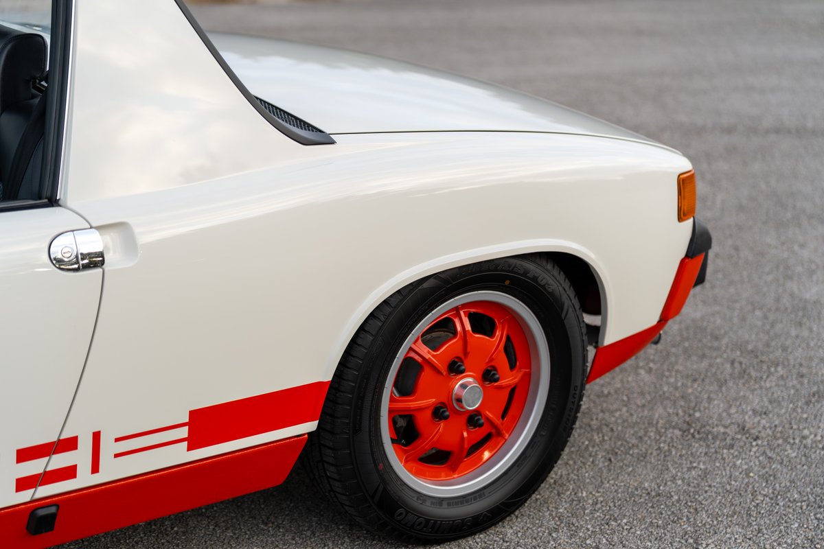 1974 Porsche 914 Can-Am in cream white with red livery and orange racing rims.