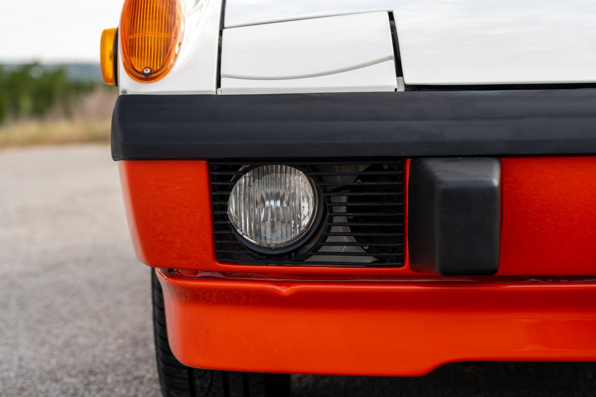Front view of a 1974 Porsche 914 Can-Am with a white hood & orange bumper and trim.