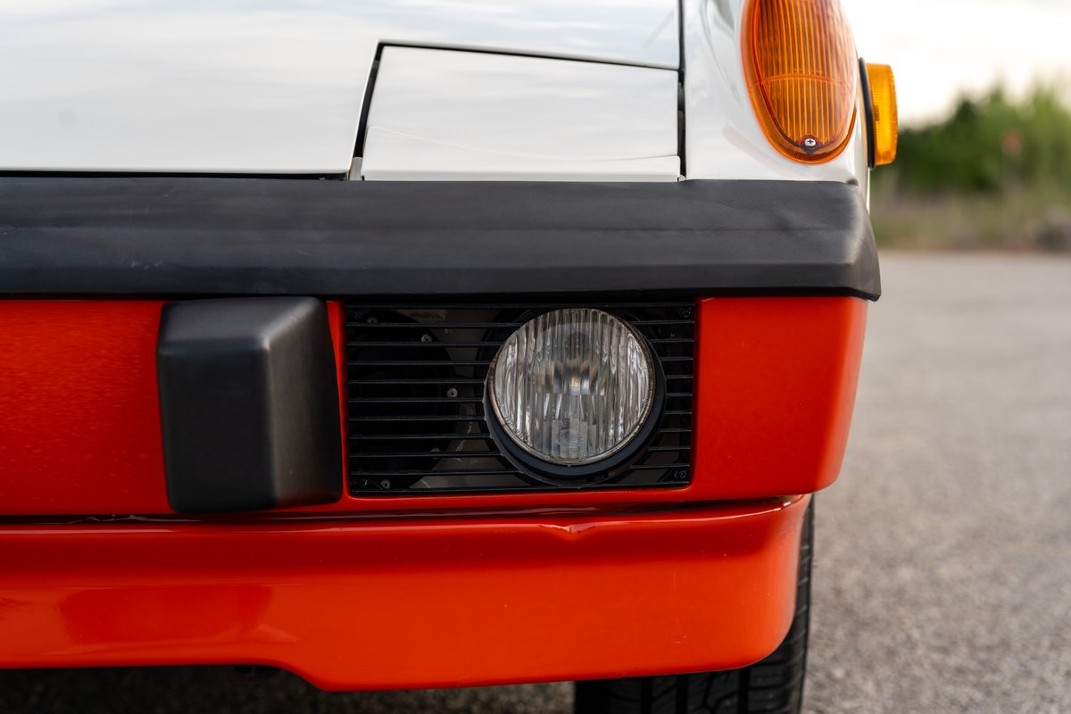 Front view of a white 1974 Porsche 914 Can-Am with orange bumper trim and a black grille.