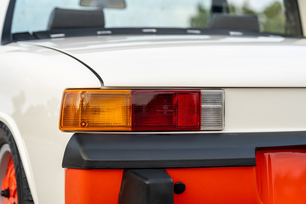 Close-up of a white 1974 Porsche 914 Can-Am with orange trim and bumper details.