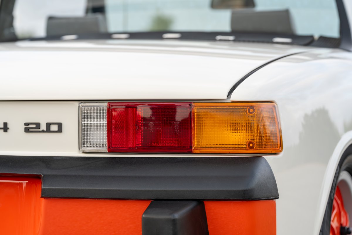 Close-up of the rear tail light assembly on a white 1974 Porsche 914 Can-Am LE with orange accents.