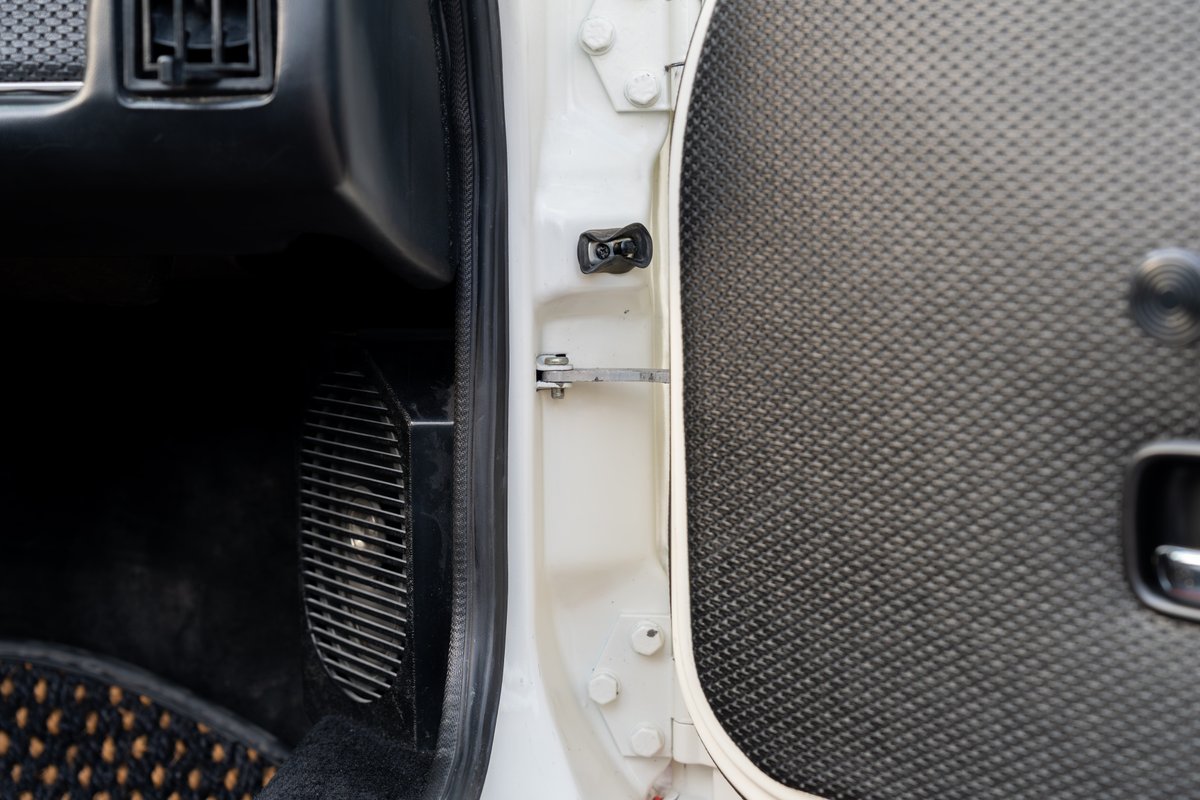 Interior of a white 1974 Porsche 914 with textured door panel and vent.
