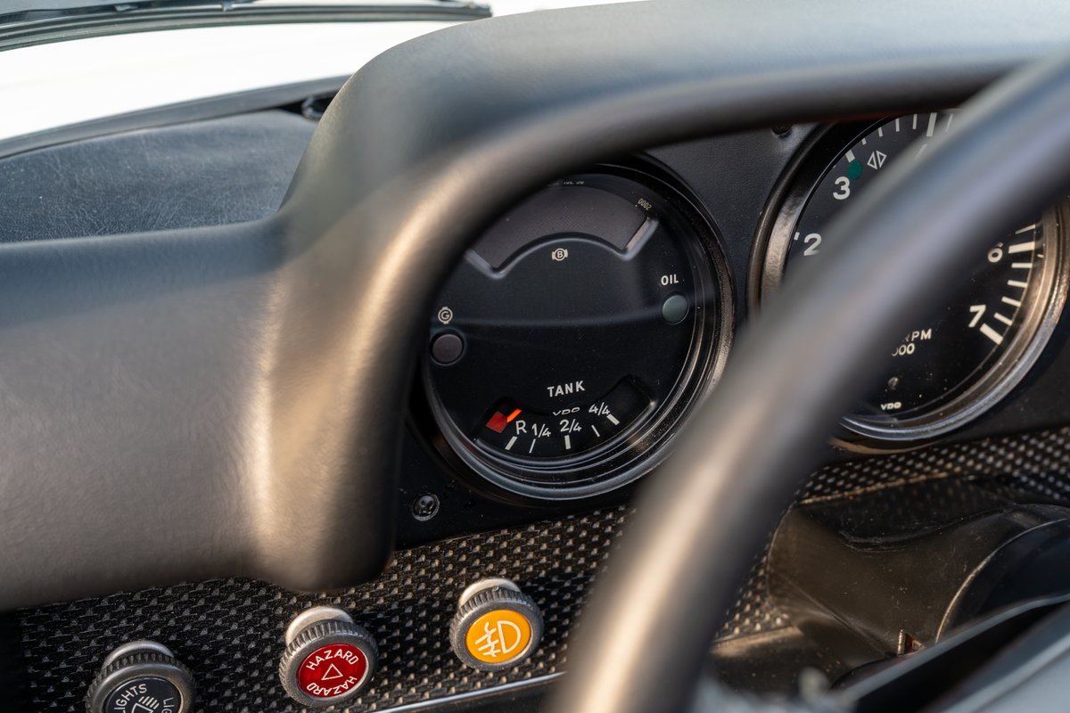 Classic 1974 Porsche 914 dash: fuel gauge, tachometer, and hazard lights with carbon fiber trim.