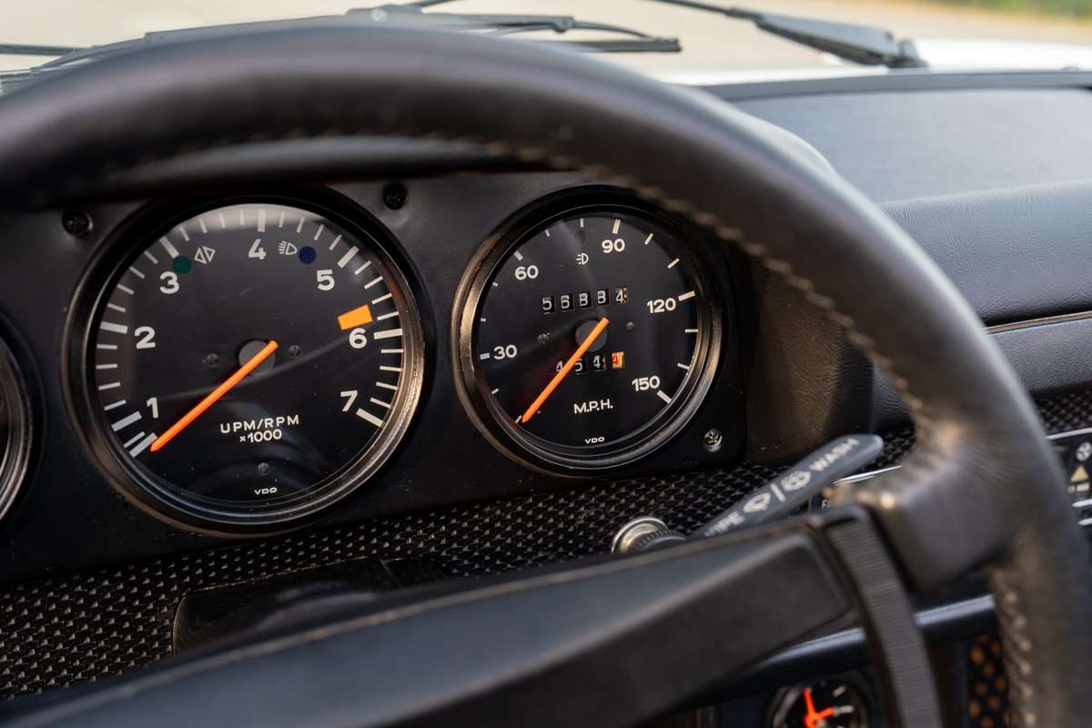 Classic Porsche 914 Can-Am gauges and steering wheel. Orange tachometer and speedometer needles.
