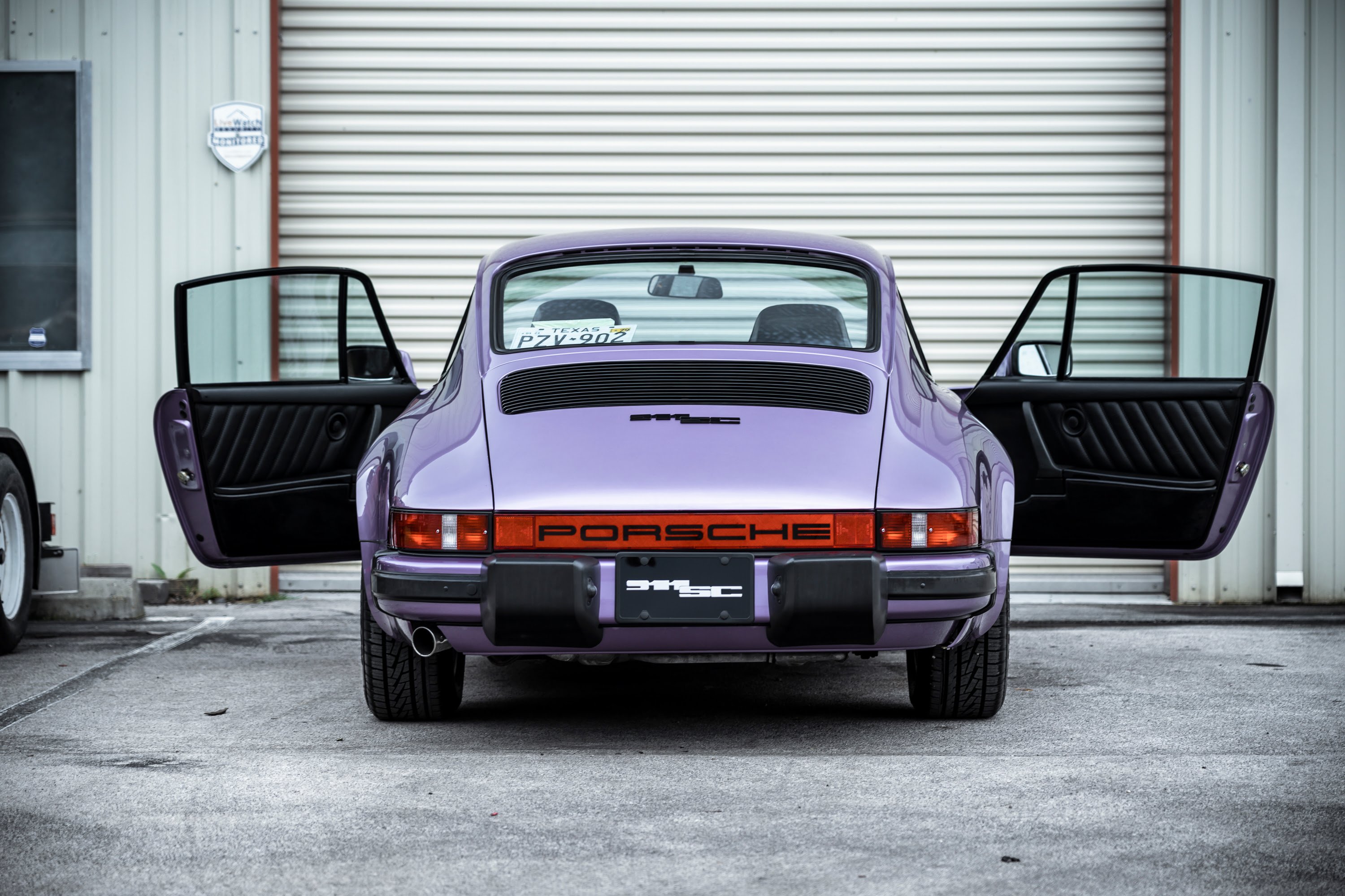Doors open on a purple 911SC.