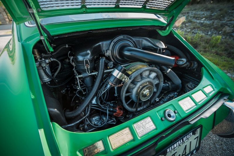 Close-up of a Conda Green 1971 Porsche 911E's open rear engine bay, revealing its iconic air-cooled flat-six engine.