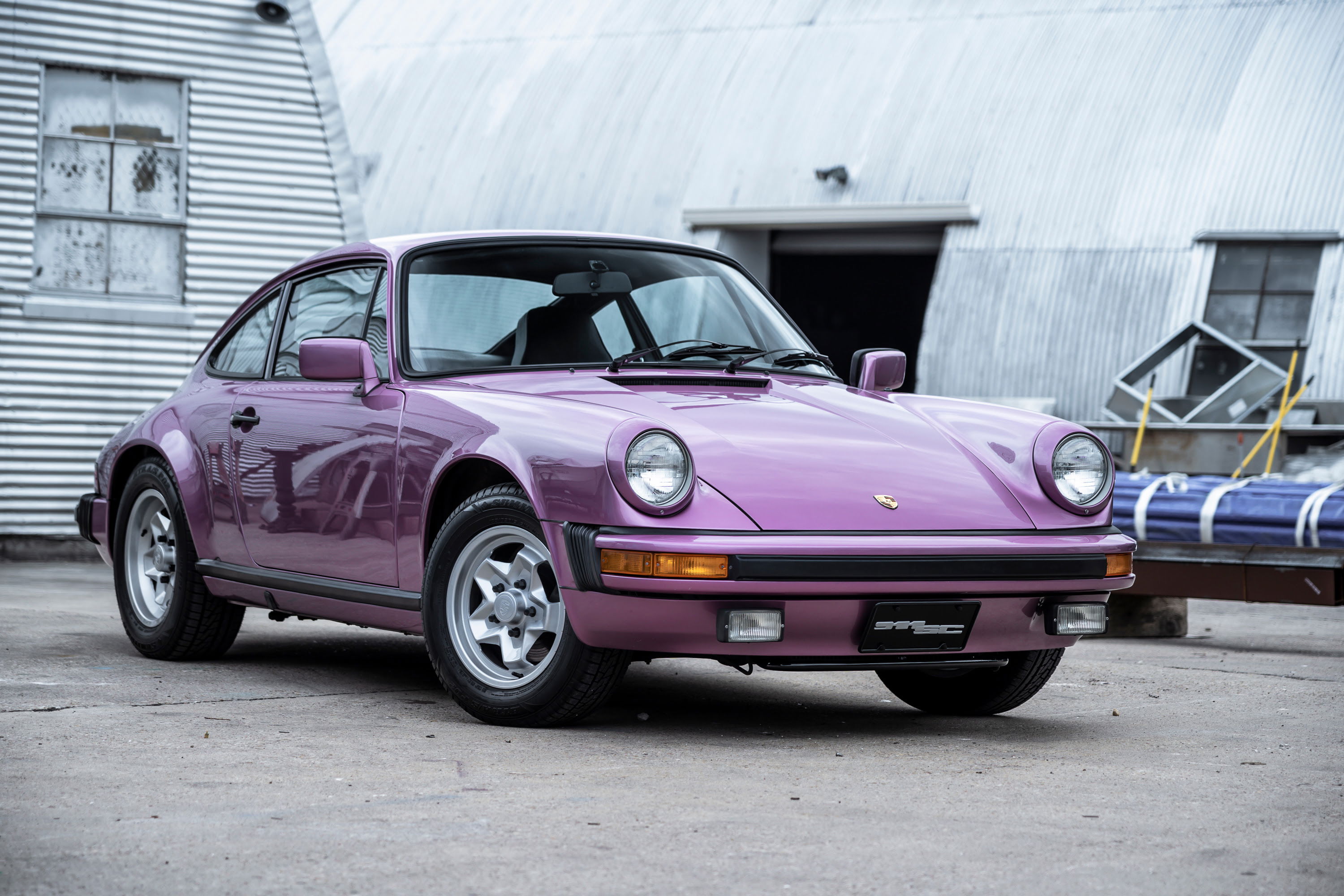 Purple Porsche 911 G-series coupe with silver Fuchs rims, black impact bumpers. Classic German sports car, Austin.
