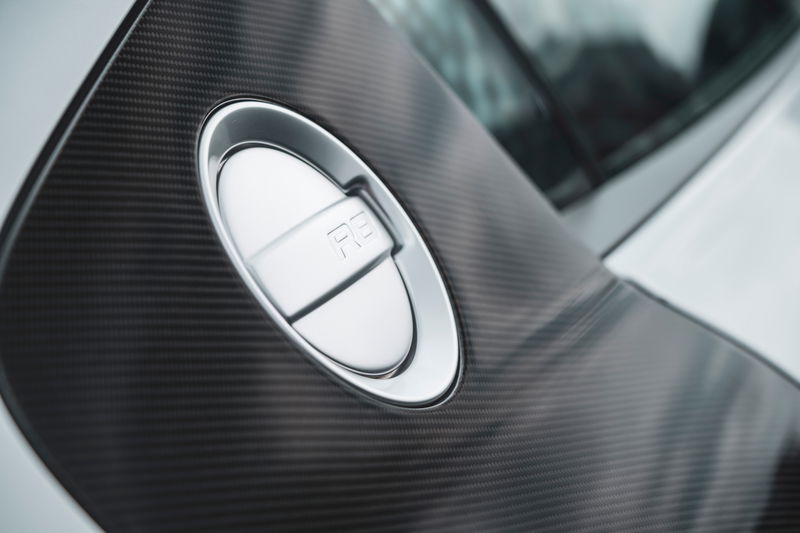 Silver Audi R8 supercar close-up: carbon fiber side blade details the prominent metallic R8 fuel filler cap.