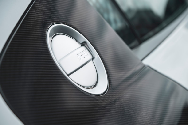 Silver Audi R8 supercar close-up: carbon fiber side blade details the prominent metallic R8 fuel filler cap.