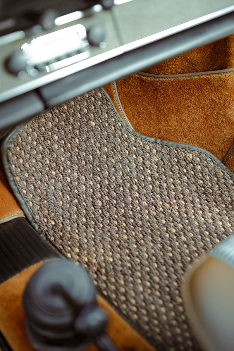 1973 Porsche 911S interior: detailed view of a classic brown coco mat, tan interior trim, and vintage dashboard controls.